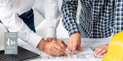 Administrativos de la construcción trabajando sobre plano