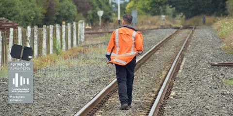 Obrero andando por las vías de un tren