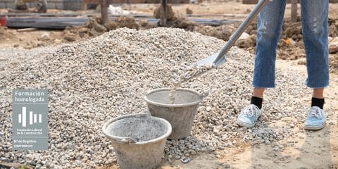 Operario de instalaciones recogiendo con cubo y pala