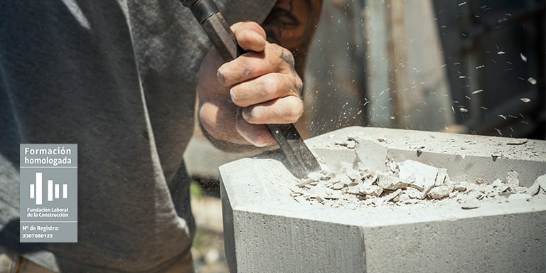 Operario de taller de materiales trabajando la piedra