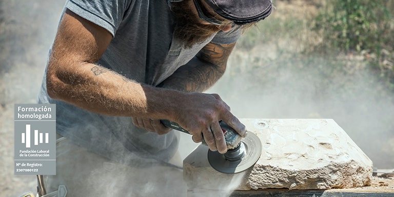 Operario de taller de materiales trabajando con piedra