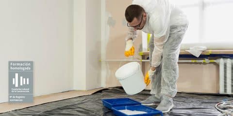 Obrero volcando un cubo de pintura blanca