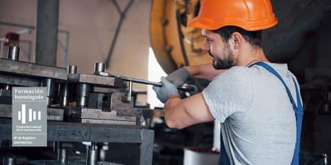 obrero arreglando maquinaria