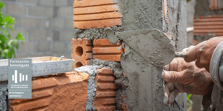 Obrero revistiendo ladrillo en exteriores